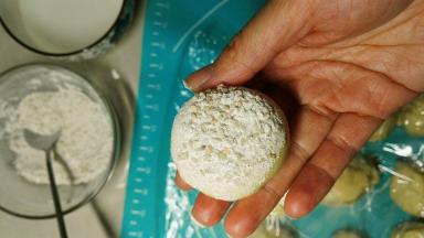 滚好的面团，底部沾水，然后再在沾料里沾一下，放入烤盘里面