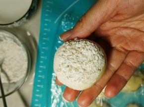 滚好的面团，底部沾水，然后再在沾料里沾一下，放入烤盘里面