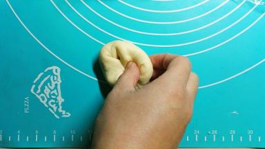 把面团分割成16份，用保鲜膜盖好，松弛5分钟，拿一份面团，用手往里折，两只手操作最好（我一个人要拍照所以只看到一只手），折几次后就会看到表面是光滑的了