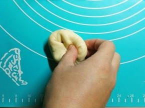 把面团分割成16份，用保鲜膜盖好，松弛5分钟，拿一份面团，用手往里折，两只手操作最好（我一个人要拍照所以只看到一只手），折几次后就会看到表面是光滑的了