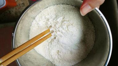 把低筋面粉全部倒入椰蓉里面，用筷子搅拌几下，让椰蓉粘上低筋面粉