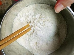 把低筋面粉全部倒入椰蓉里面，用筷子搅拌几下，让椰蓉粘上低筋面粉