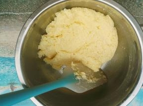 把搅拌好的椰蓉全部倒入搅拌好的黄油里面，用手动打蛋器画圈圈将椰蓉跟黄油混合均匀，再用刮刀将盆壁上的椰蓉刮到中间在盆子上面盖上保鲜膜，静置30分钟