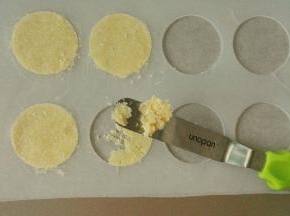 准备好一张油纸，用小号的抹刀挑一块椰蓉面团，用瓦片模具来整形，这样就可以保证每一块饼干都是一样薄的，这个模具淘宝上有卖