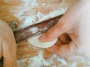 取一个小面剂开始擀皮，左手捏住面剂上方，右手拿擀面杖，左右手配合，左手捏住面剂子，右手往上推擀面杖，推到面片过中间一点往回拉，往回拉擀面杖的同时，左手逆时针转动一下面片，如此循环大约面片转动一周时一个饺子皮就擀好了(一个连贯动作下来大概几秒钟，刚开始做可能有点慢，多做几次熟练了就好了)