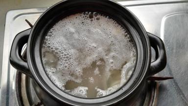 砂锅锅内添水（水大约是猪皮的三倍），放入100克猪皮、料盒、放点料酒。大火烧开撇净浮沫及浮油，盖盖转最小火熬30分钟。