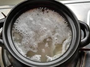 砂锅锅内添水（水大约是猪皮的三倍），放入100克猪皮、料盒、放点料酒。大火烧开撇净浮沫及浮油，盖盖转最小火熬30分钟。