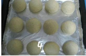 再次将面团排气滚圆，排放入烤盘，盖上保鲜膜进行二次发酵；