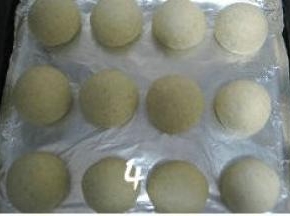 再次将面团排气滚圆，排放入烤盘，盖上保鲜膜进行二次发酵；