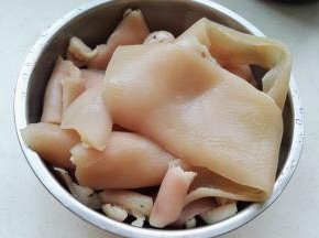 猪皮用刀把带皮那面初步刮刮，泡水洗干净。 锅中添水，放入料酒、猪皮，水开后焯水三分钟。洗净血沫，用镊子或厨房专用眉夹把残留的猪毛逐根拔干净。(这可是个考验耐心和细心的活哦。)