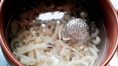 坤博砂锅锅内添水（水大约是猪皮的三倍），放入切好的猪皮条、料盒、放点料酒。