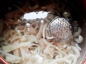 坤博砂锅锅内添水（水大约是猪皮的三倍），放入切好的猪皮条、料盒、放点料酒。