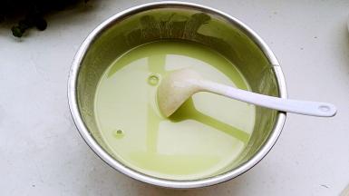 倒入菠菜汁用筷子顺着一个方向搅成无颗粒顺滑的稠面糊，慢慢加入水搅拌稀释。