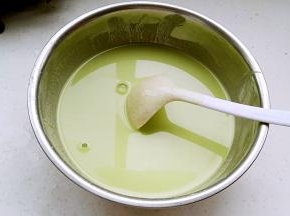 倒入菠菜汁用筷子顺着一个方向搅成无颗粒顺滑的稠面糊，慢慢加入水搅拌稀释。