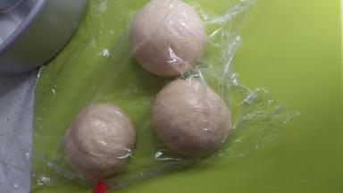 把面团拿出来排气后分成4个小团，揉成圆后让面团静止20分钟。