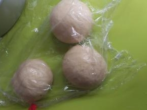 把面团拿出来排气后分成4个小团，揉成圆后让面团静止20分钟。