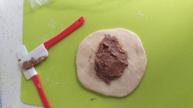 准备好巧克力酱，把静止好的面团排气，后拿适量的巧克力酱包进去。