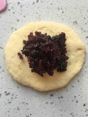 松弛好的面团压扁，包入紫米馅