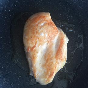 平底锅内倒入适量食用油，将鸡肉煎至两面金黄。