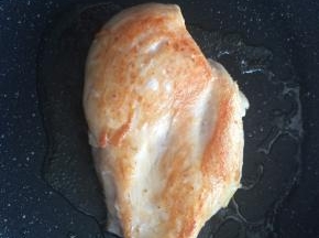 平底锅内倒入适量食用油，将鸡肉煎至两面金黄。