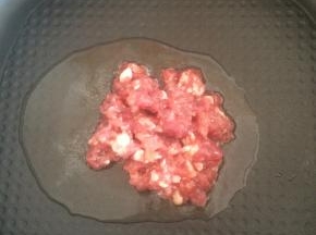 锅内倒入适量食用油，下入腌好的肉馅翻炒。