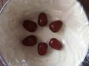 碗底铺保鲜膜，便于脱模，大枣洗干净，摆好花型。
