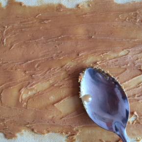 豆皮展开，挤上花生酱。
用勺背刮平，涂抹均匀。