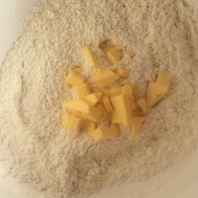 面粉中加入室温软化并切成小块的黄油，双手揉搓至颗粒状。