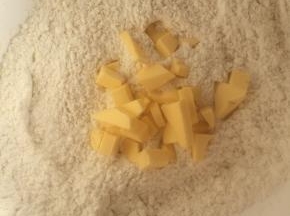 面粉中加入室温软化并切成小块的黄油，双手揉搓至颗粒状。