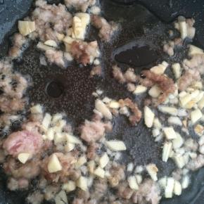 肉末变色后，放入蒜末爆香。