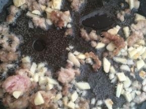 肉末变色后，放入蒜末爆香。