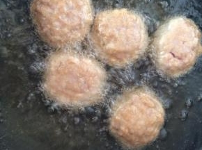 手上抹油，将肉馅揉成拳头大小的丸子。
锅中倒入食用油，油温四成热时就可以下入丸子，小火慢炸。表面金黄即可。