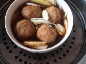 炸好的丸子放入碗中，放入葱姜片，少许酱油，加入适量热水，隔水蒸一个小时。