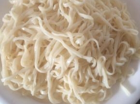 煮熟的面条过凉水放入盘中。
