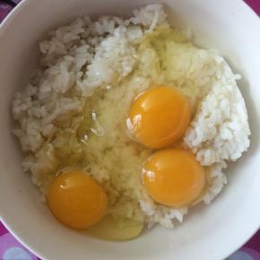 鸡蛋磕入米饭中。