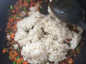 炒至蔬菜7分熟，放入米饭继续翻炒。