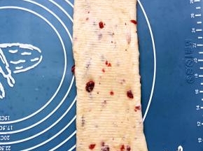 取一个松弛好的面团擀成长点的椭圆形