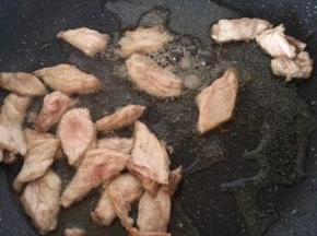平底锅倒入适量食用油，放入肉片煸炒。