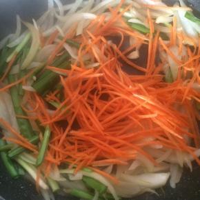 加入洋葱、胡萝卜丝、韭菜翻炒。