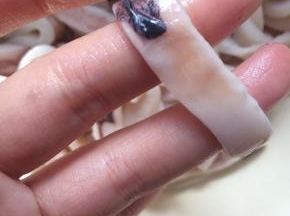 撕去鱿鱼表面的黑色膜。