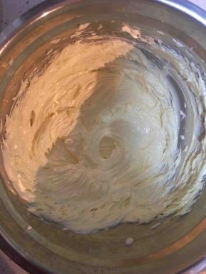 牛奶和白砂糖加热溶化放凉。黄油软化打发至白色，分多次加入糖水，打发至有光泽