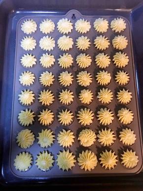 将饼干糊装入放好裱花嘴的裱花袋中，挤出花型