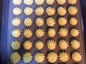 将饼干糊装入放好裱花嘴的裱花袋中，挤出花型