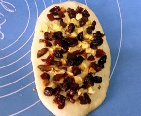 翻面，铺上适量的果料与坚果。由上至下卷起；