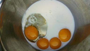 蛋黄盆里加入牛奶，用手动打蛋器搅拌均匀