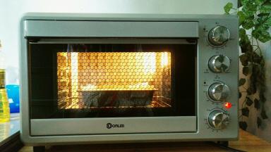 准备点温水放入东菱自带的烤盘里面，放入最底下一层，再在烤盘上放入烤网，将蛋糕糊模具放在烤网上面，上下火175度烤10分钟，再转150度烤40分钟