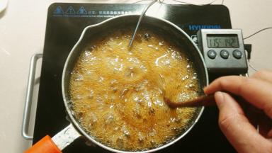 糖浆煮开后，温度调小点，我是开的500℃，这时候把温度计插进去，边熬边搅拌