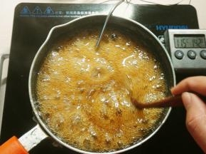 糖浆煮开后，温度调小点，我是开的500℃，这时候把温度计插进去，边熬边搅拌