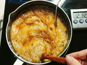 现在糖浆熬到132℃了，一般都是要超过135℃，糖温达到135℃后把黄油从锅中拿出来，把打蛋盆坐锅上，让蛋白跟蛋白盆都保持温度，这样糖浆倒进去就不会结块，为了保险起见我都是熬到140℃，如果你的温度达不到，糖就会软，粘牙