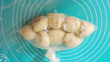 在保鲜袋袋里倒入少量的植物油，将面团放进去，让植物油包住面团，只要薄薄的一层，目的就是让面团不粘在一起，扎紧袋口放冰箱冷藏醒发2个小时以上，也可以头天晚上做好过夜，早上起来做也一样的